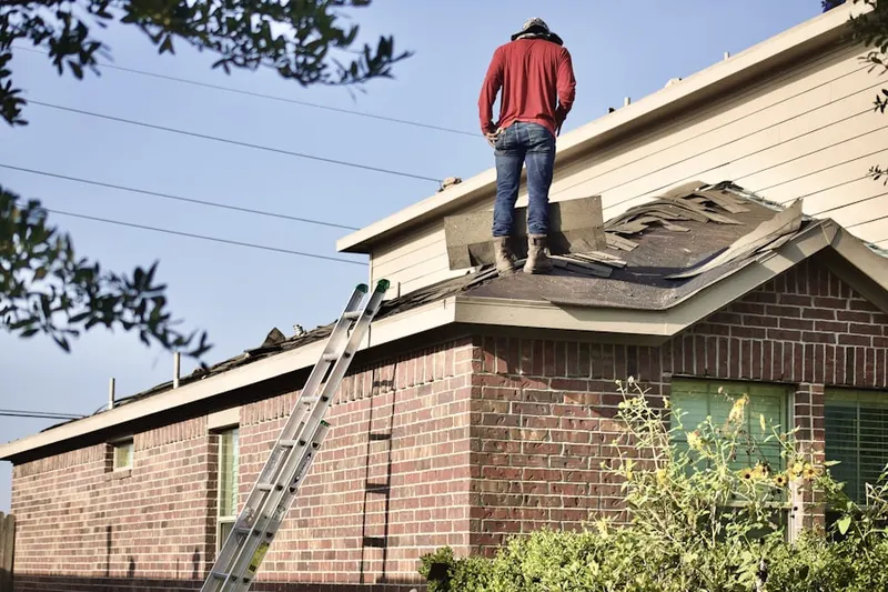 Professional roofer working on a residential roof in Putney